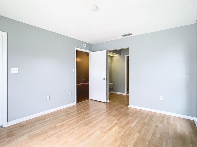 spare room with light wood-type flooring, baseboards, and visible vents