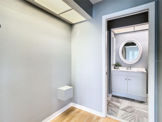 interior space featuring baseboards, wood finished floors, and vanity