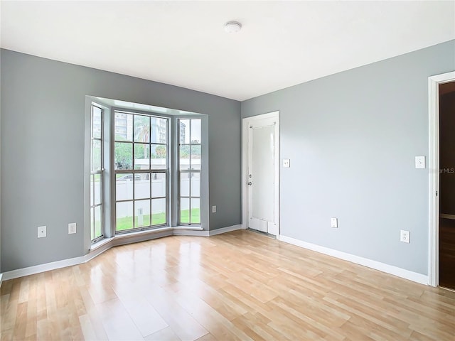 spare room featuring light wood-style floors and baseboards