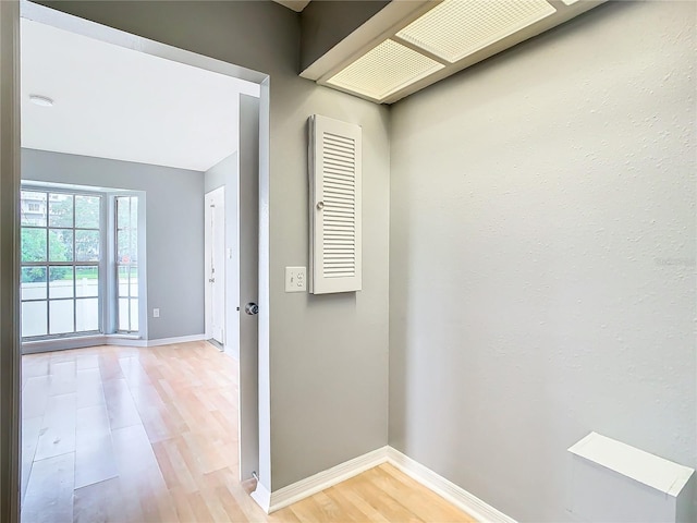 corridor featuring baseboards and light wood-type flooring