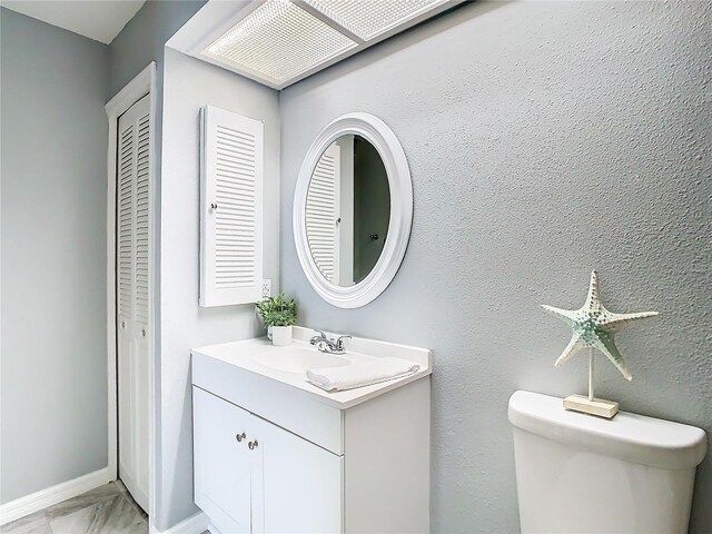 bathroom featuring tile patterned floors, vanity, and toilet