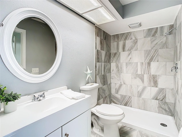 bathroom featuring vanity, visible vents, tiled shower, toilet, and marble finish floor