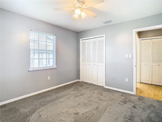 unfurnished bedroom featuring baseboards, carpet floors, visible vents, and a closet