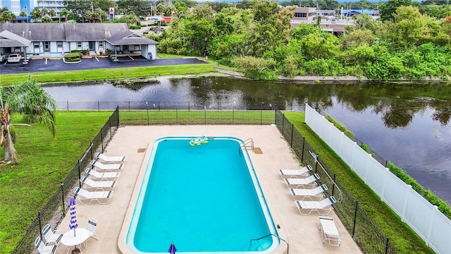 view of pool featuring a patio area, a yard, and a water view