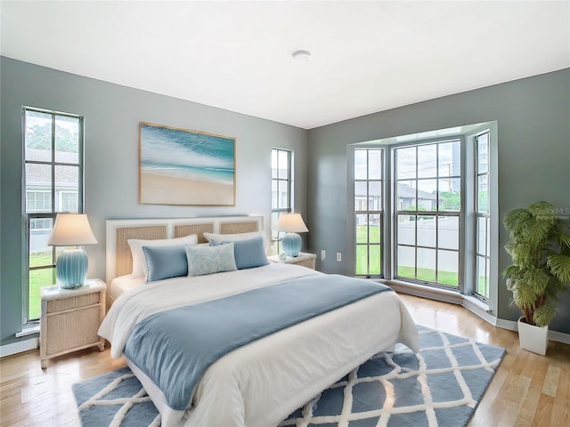 bedroom with light wood finished floors and baseboards