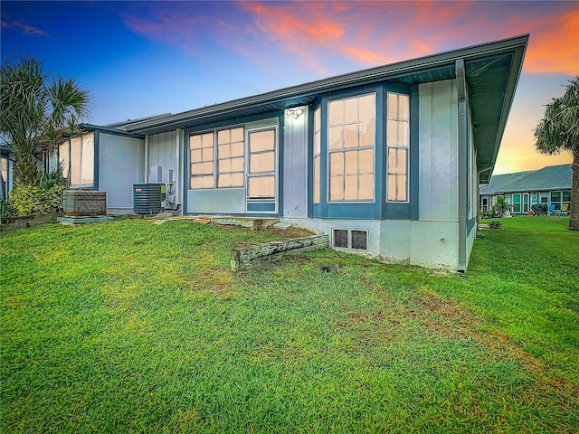 back of house featuring a lawn and central AC