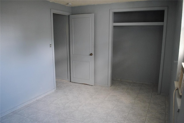 unfurnished bedroom featuring a closet and light tile patterned flooring