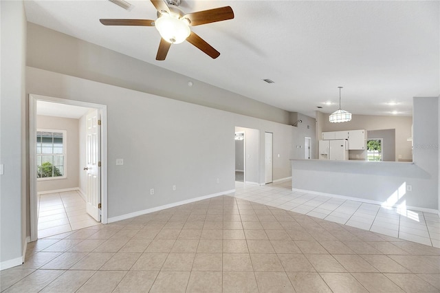 unfurnished living room featuring a wealth of natural light, lofted ceiling, and light tile patterned floors