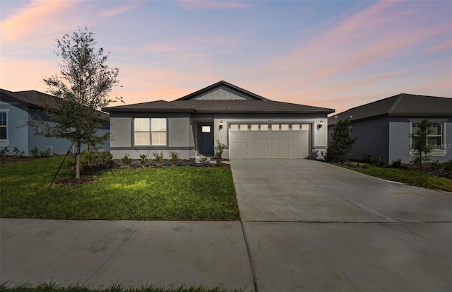 prairie-style home with a yard and a garage