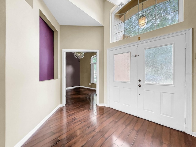 foyer entrance featuring a towering ceiling, hardwood / wood-style flooring, and french doors