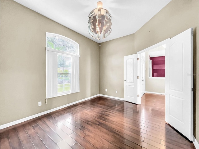 unfurnished room featuring hardwood / wood-style floors and an inviting chandelier