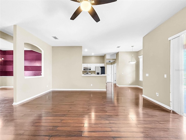 unfurnished living room with ceiling fan, plenty of natural light, and hardwood / wood-style floors