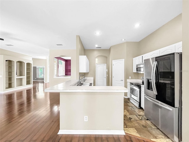 kitchen with white cabinets, appliances with stainless steel finishes, light hardwood / wood-style floors, sink, and kitchen peninsula