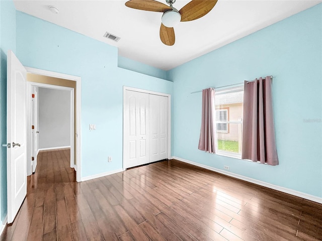 unfurnished bedroom with ceiling fan, a closet, and wood-type flooring