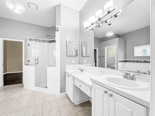 bathroom with tile patterned flooring, vanity, and a shower with shower door