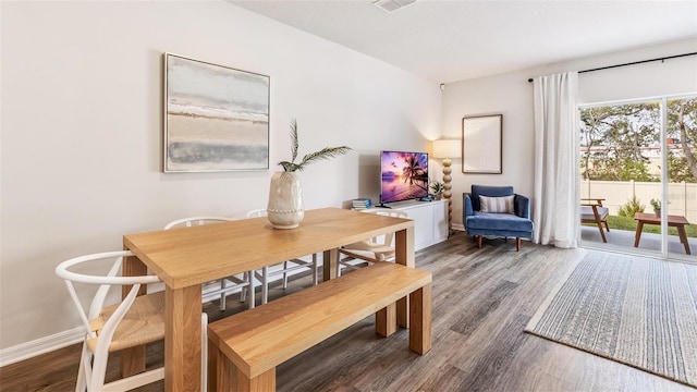 dining space with visible vents, baseboards, and wood finished floors