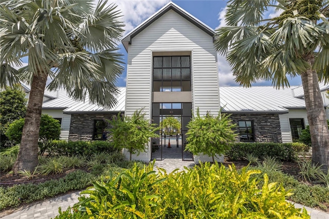 view of front of home featuring metal roof, stone siding, and a standing seam roof