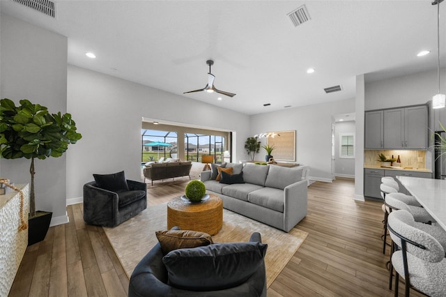 living area featuring visible vents, baseboards, and hardwood / wood-style flooring