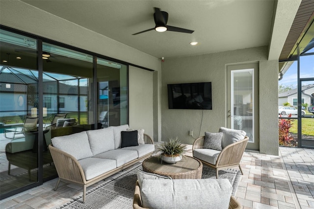 view of patio with glass enclosure, an outdoor living space, and ceiling fan