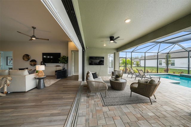 view of patio with an outdoor living space, an outdoor pool, a lanai, and ceiling fan