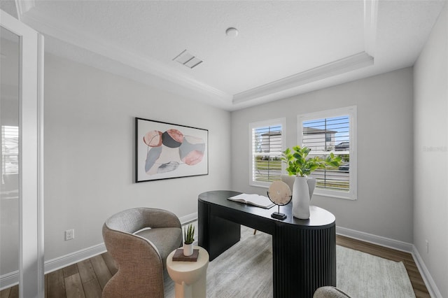 home office featuring baseboards, a raised ceiling, and wood finished floors