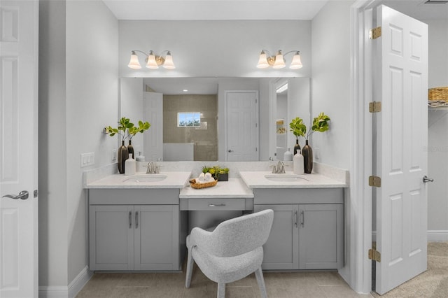 bathroom featuring a sink, baseboards, and two vanities