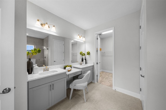 full bathroom featuring a tile shower, vanity, a walk in closet, and baseboards