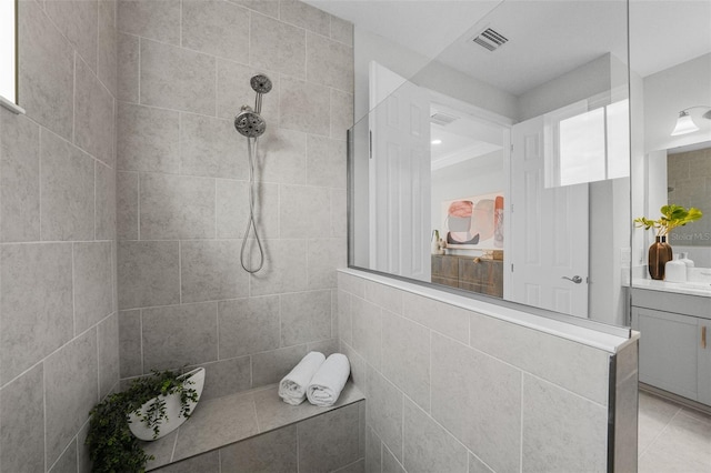 full bathroom featuring vanity, a walk in shower, visible vents, and tile patterned flooring