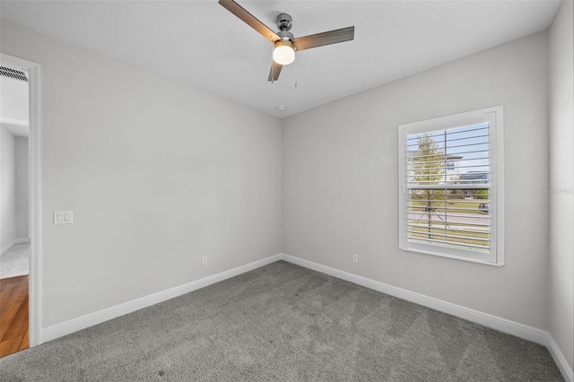 carpeted empty room with baseboards and a ceiling fan