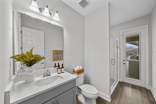 full bathroom featuring visible vents, a shower stall, toilet, wood finished floors, and vanity