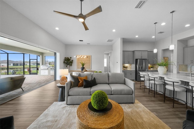 living area with visible vents, recessed lighting, ceiling fan, and wood finished floors