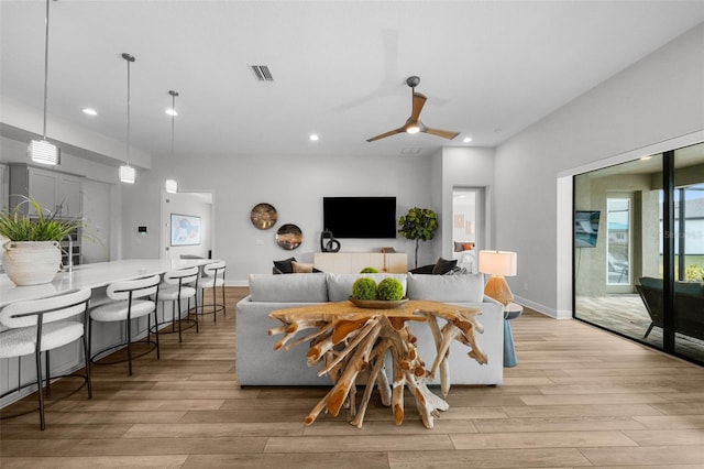 living area featuring recessed lighting, visible vents, light wood-style flooring, and baseboards