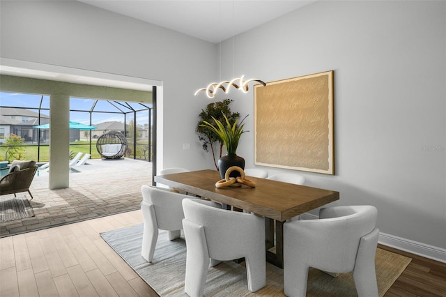 dining area featuring baseboards, wood finished floors, and a sunroom