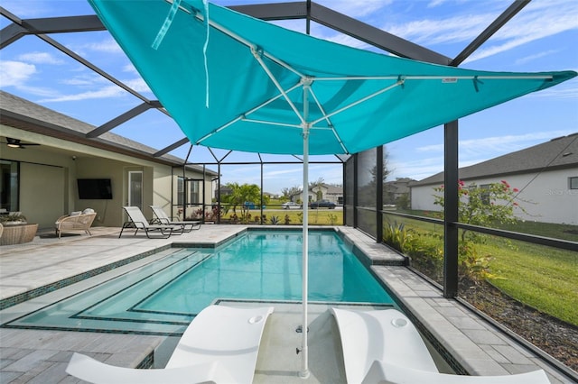 pool featuring glass enclosure, a patio, and a ceiling fan