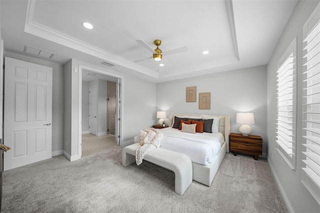 bedroom with light carpet, visible vents, baseboards, and a tray ceiling