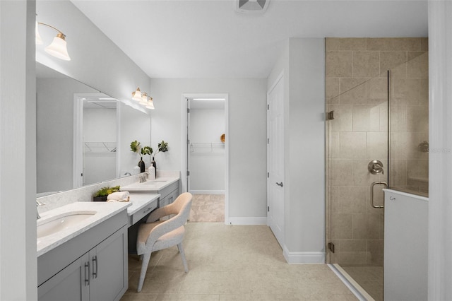 full bathroom with vanity, a spacious closet, baseboards, and a stall shower