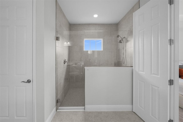 bathroom with tile patterned floors, a shower stall, and baseboards