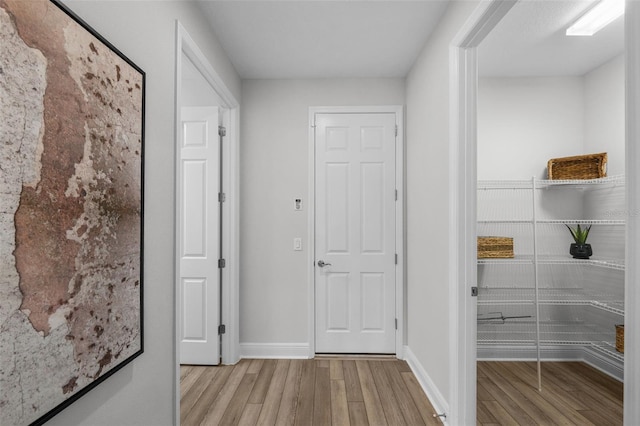 hall featuring baseboards and wood finished floors