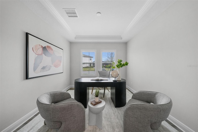 office featuring visible vents, wood finished floors, baseboards, crown molding, and a raised ceiling