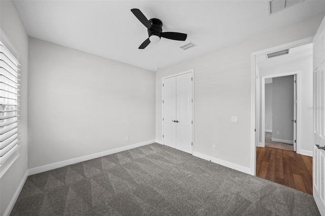 unfurnished bedroom featuring a closet, visible vents, carpet, and baseboards