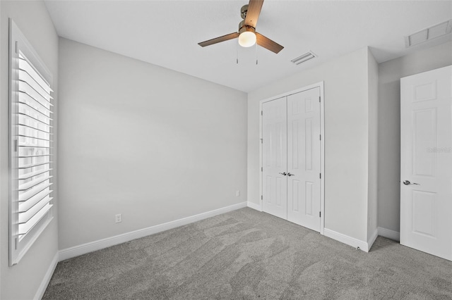 unfurnished bedroom with carpet, visible vents, and baseboards