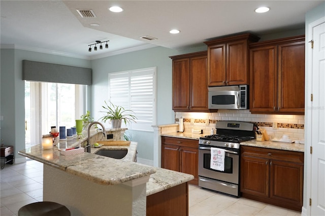 kitchen featuring appliances with stainless steel finishes, crown molding, decorative backsplash, and sink