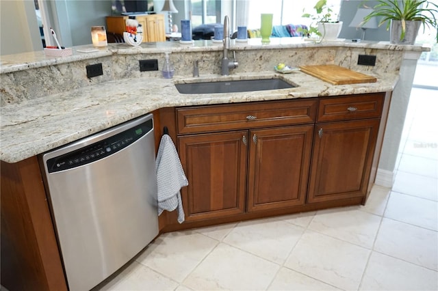 kitchen with light stone counters, dishwasher, plenty of natural light, and sink