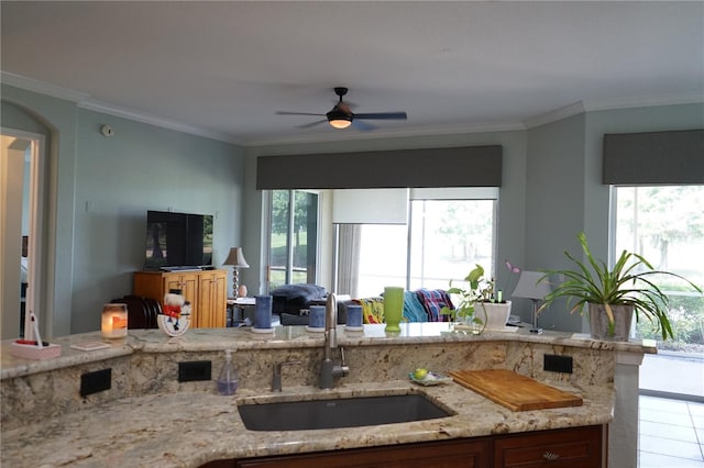 kitchen featuring plenty of natural light, sink, and light stone counters