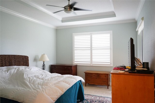 carpeted bedroom featuring crown molding, ceiling fan, and a tray ceiling