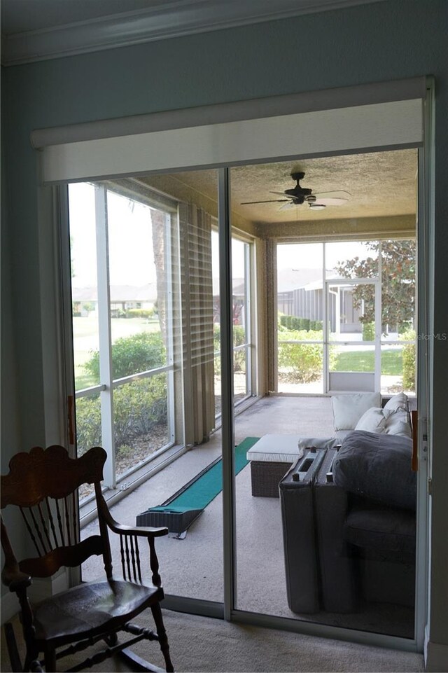 sunroom / solarium with a healthy amount of sunlight and ceiling fan