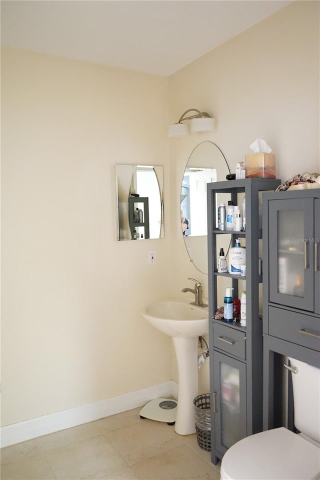 bathroom featuring sink, tile patterned flooring, and toilet