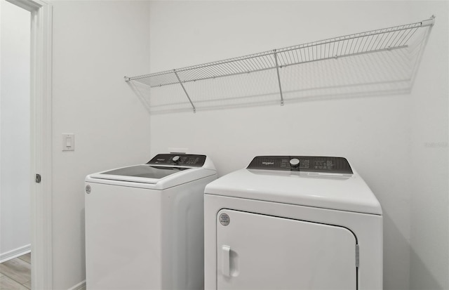 clothes washing area featuring light hardwood / wood-style flooring and independent washer and dryer