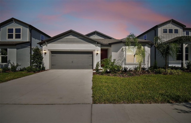 view of front of home with a garage and a yard