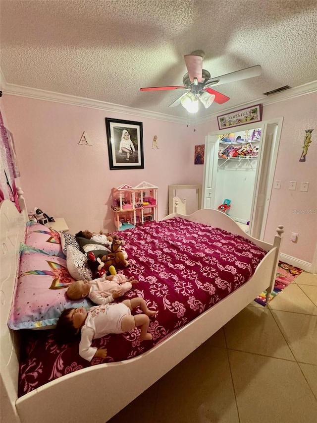 bedroom featuring a textured ceiling, ceiling fan, and tile patterned floors